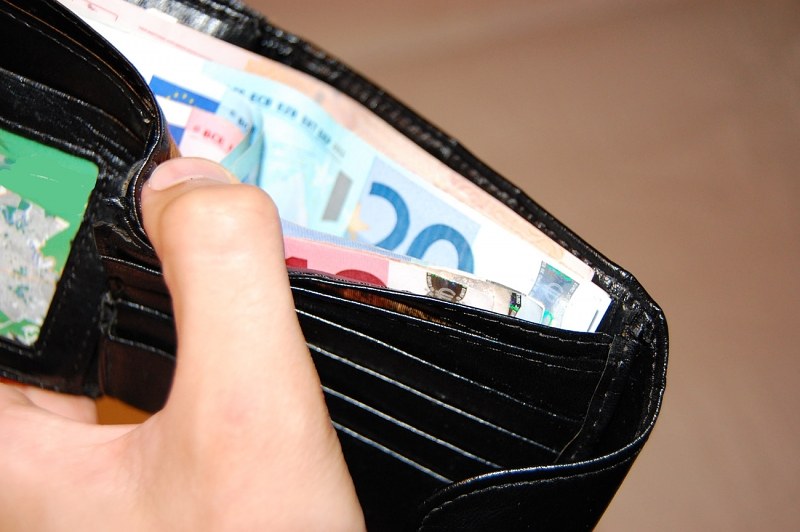 Hand mit geöffnetem Geldbeutel und Euro-Scheinen